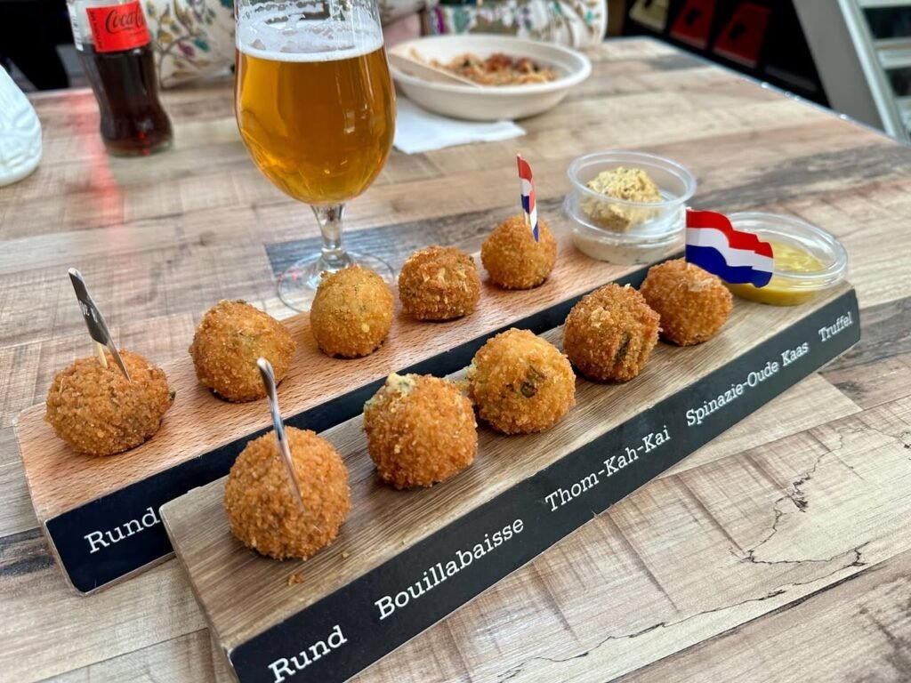 A selection of finger foods including Rund and Bouillabaisse balls served on wooden boards with beer.
