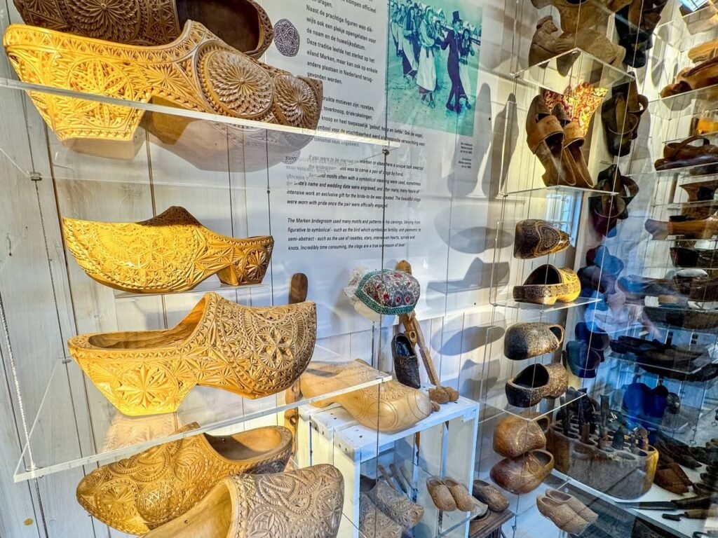 A display of intricately woven basket shoes and pottery in a museum setting.