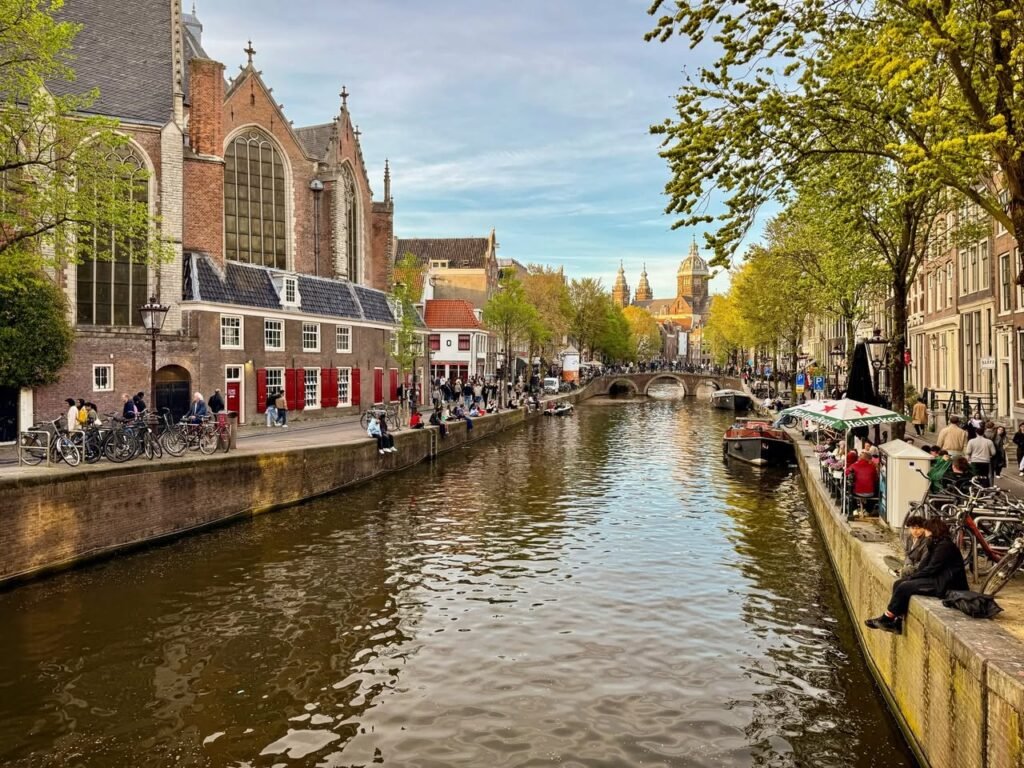 A scenic view of Amsterdam's canals with historic architecture and cycling, perfect for a Dutch adventure.