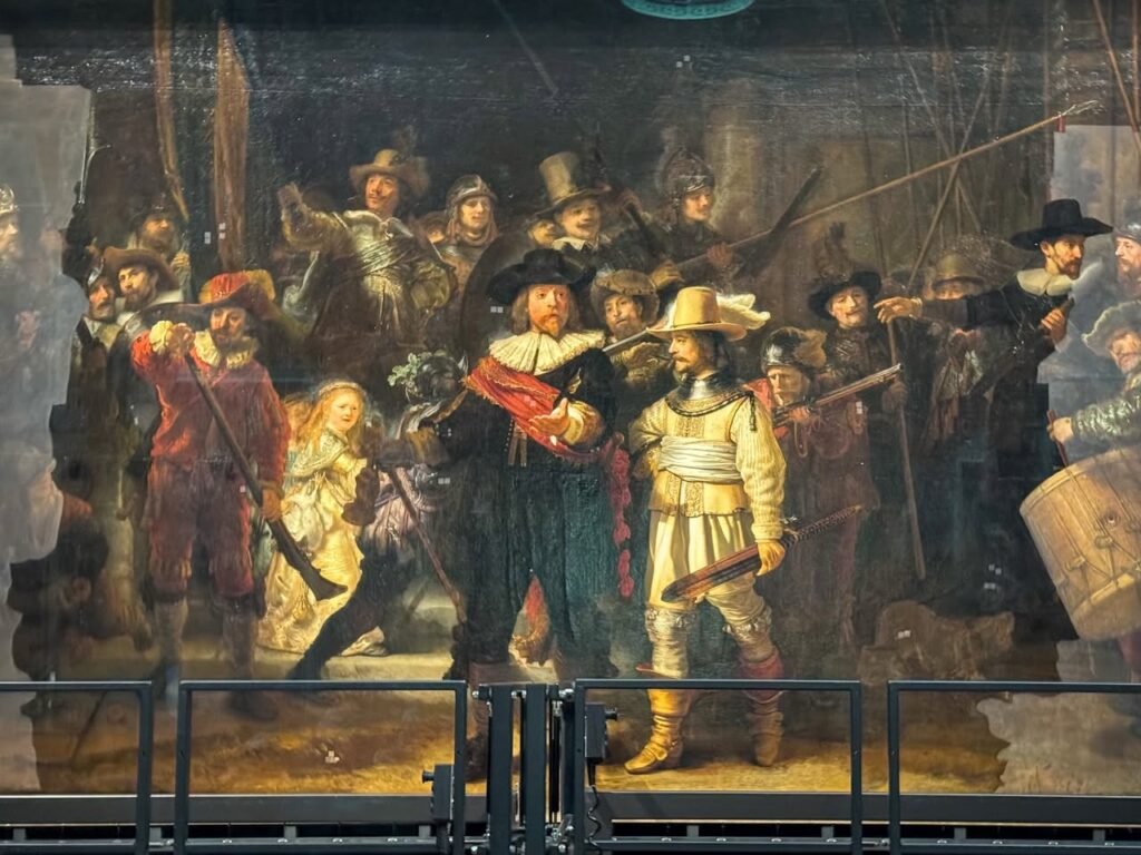 Close-up views of a large historical painting depicting a group scene, captured behind a safety railing.