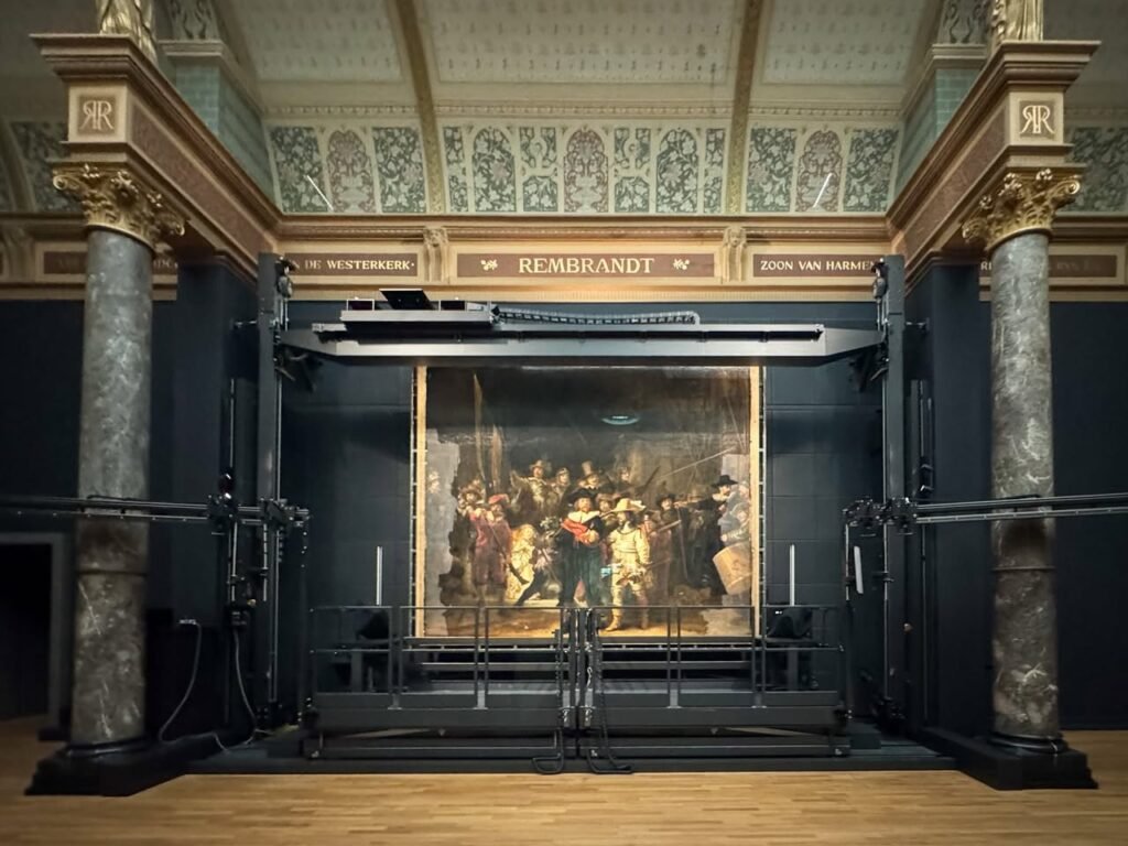 Restoring the Night Watch, The Rembrandt Gallery, showcasing classical marble columns and ornate gilded architectural details in the Rijksmuseum. This image highlights the historic baroque architecture that frames Rembrandt's masterpiece.