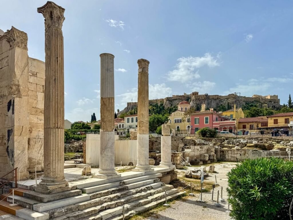 Ancient stone columns and ruins at the Towers of Minos archaeological site in Heraklion, Crete, under a bright blue sky.