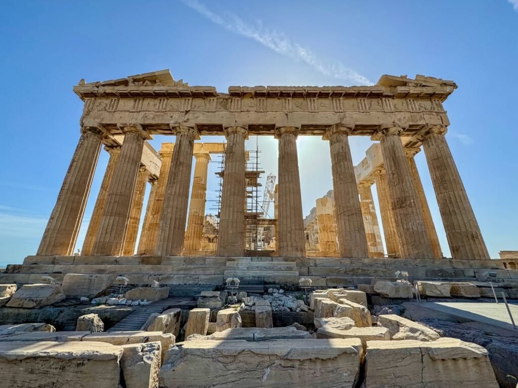 Photographs of ancient Greek columns and ruins under a bright blue sky, capturing the historic Parthenon.