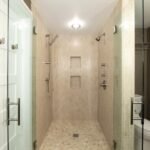 Twins! A beautifully tiled walk-in shower featuring glass walls and a step-in design.