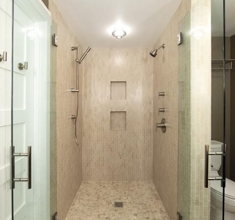 A beautifully tiled walk-in shower featuring glass walls and a step-in design.