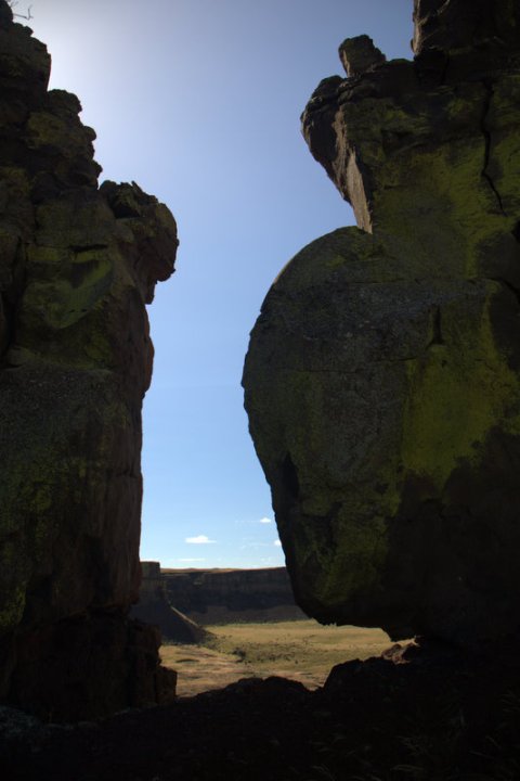 A stack of strangely shaped rocks against a clear blue sky.