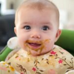 Baby enjoying family time in a high chair booster seat.