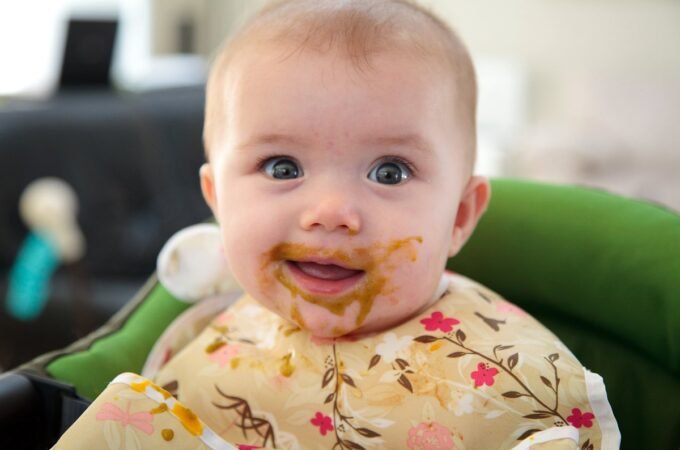 Baby enjoying family time in a high chair booster seat.