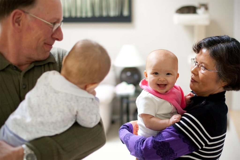 Two older adults holding and interacting with two babies in a bright indoor setting. A close-up view of one adult and a baby, plus a profile shot of the other adult and baby.