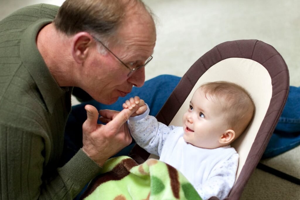 A touching portrait of a grandparent sharing a gentle moment with a baby in a modern bouncer.