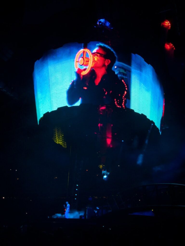 A performer singing passionately into a microphone at a live concert.