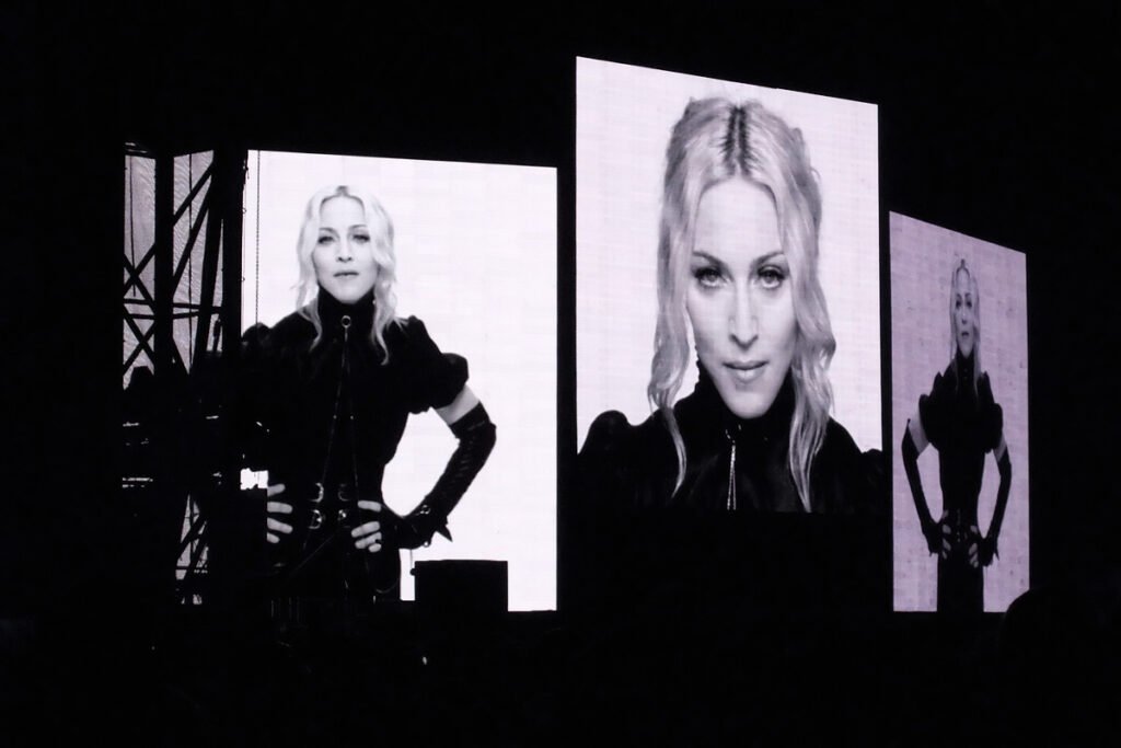Monochromatic split showcases Crystal Method performing on stage. Large screens display their striking visuals.