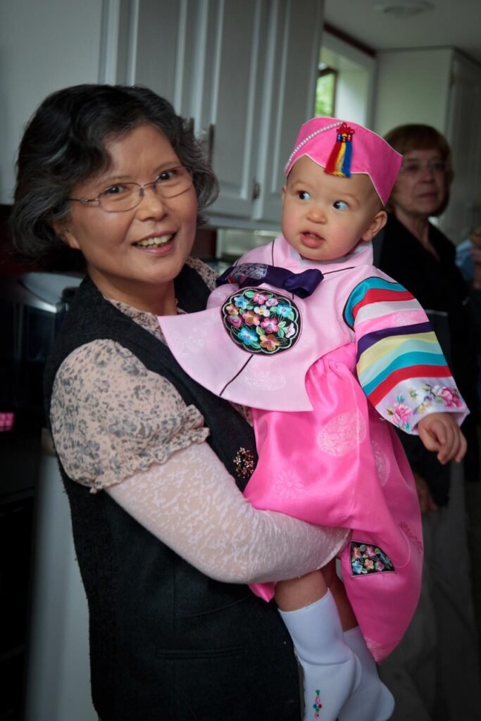 Grandmother Cradles Toddler Wearing Traditional Korean Attire