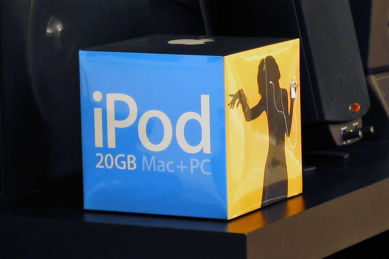 A vibrant blue and yellow box of a 20GB iPod sits on a dark surface.