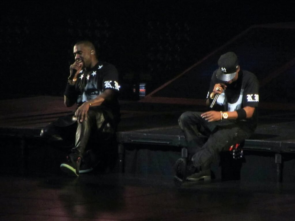 Performers on a dimly lit stage during an outdoor concert.