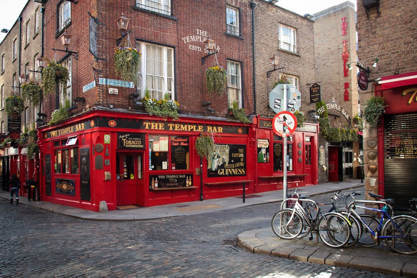 Ireland A close-up of the red brick facade of The Temple Bar pub in Dublin, with bicycles parked on the cobblestone street.