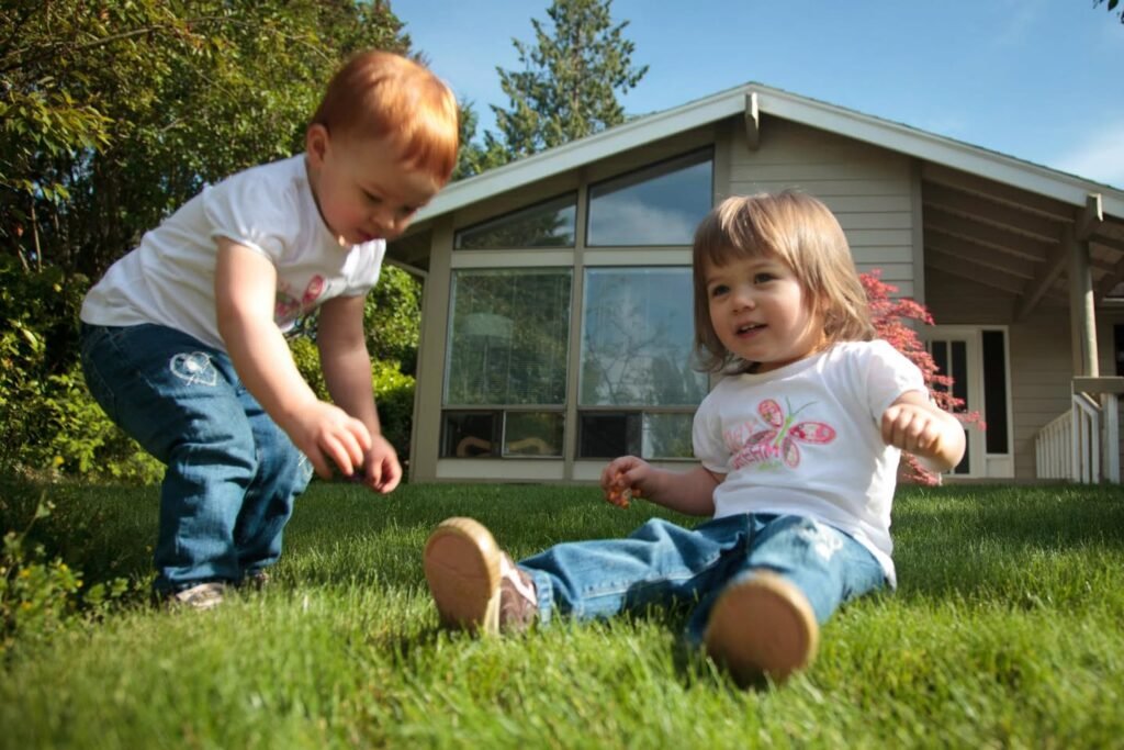 Children playing on the lawn in front of a Pacific Northwest home.