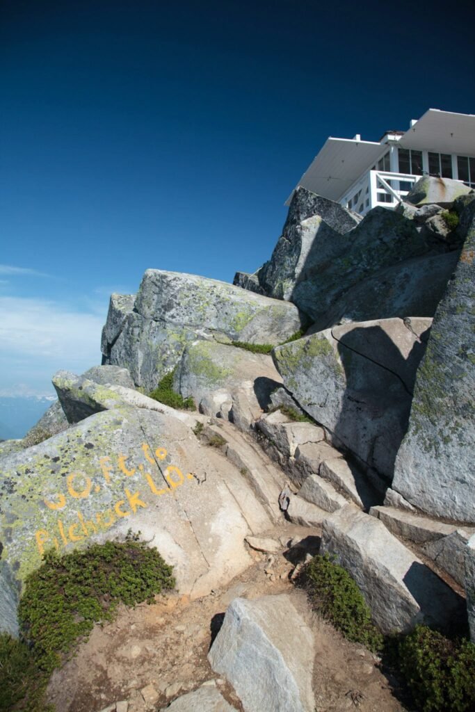 Rugged rocks and climbers scaling a steep, expansive landscape with clear blue skies.