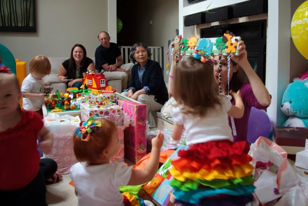 Children celebrating a birthday party with rainbow tutus and festive hats.