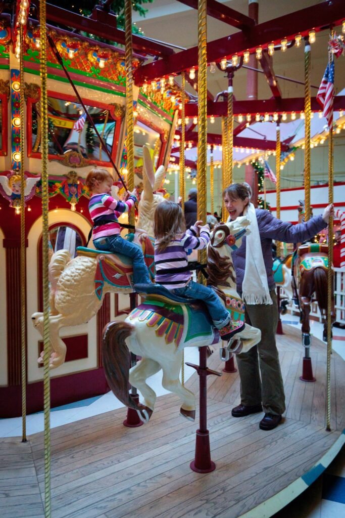 A joyful scene of children enjoying a ride on a mesmerizing indoor carousel.