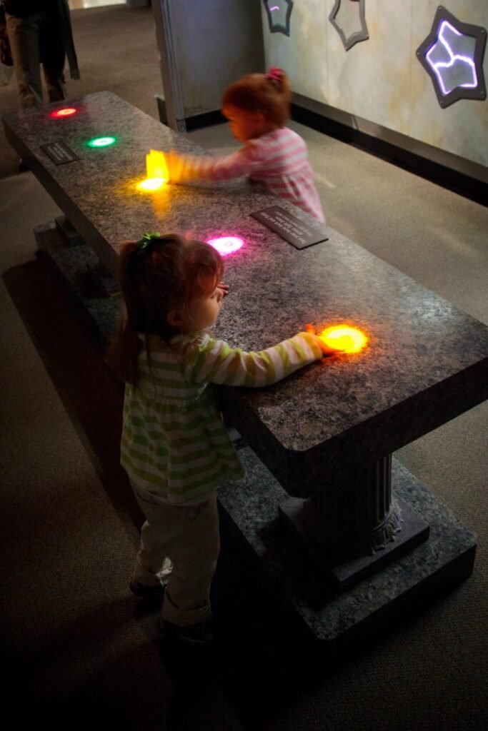 People interact with a light and interactive art exhibit at a museum in the Pacific Northwest.