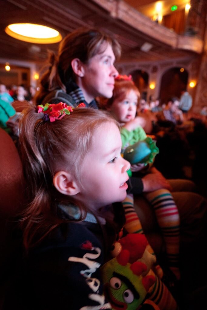 Family members seated in an auditorium enjoying a theatrical performance.