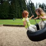 Children enjoying a ride on a tire swing at a local park.