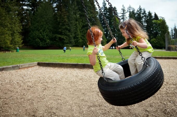 Children enjoying a ride on a tire swing at a local park.