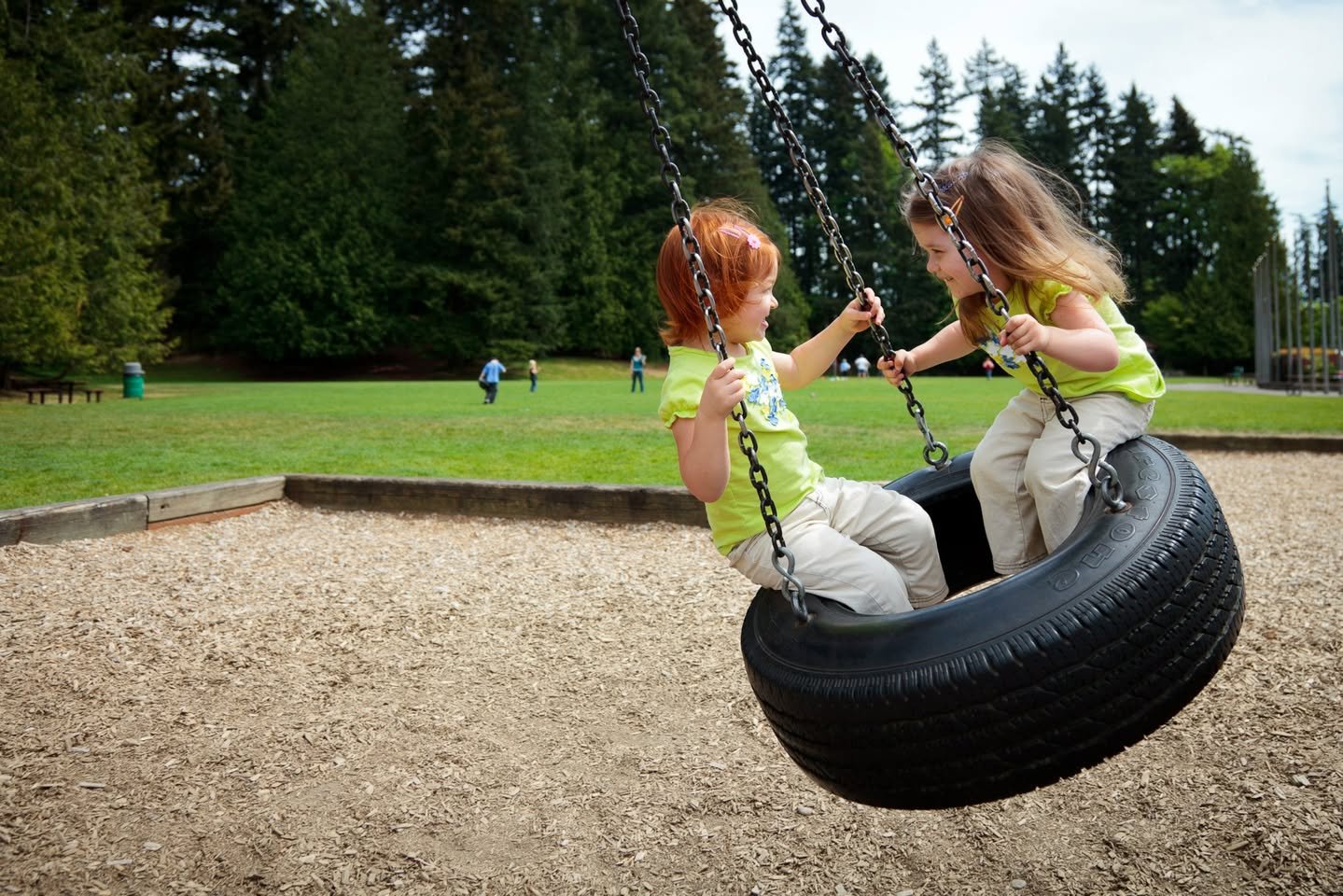 Children enjoying a ride on a tire swing at a local park.
