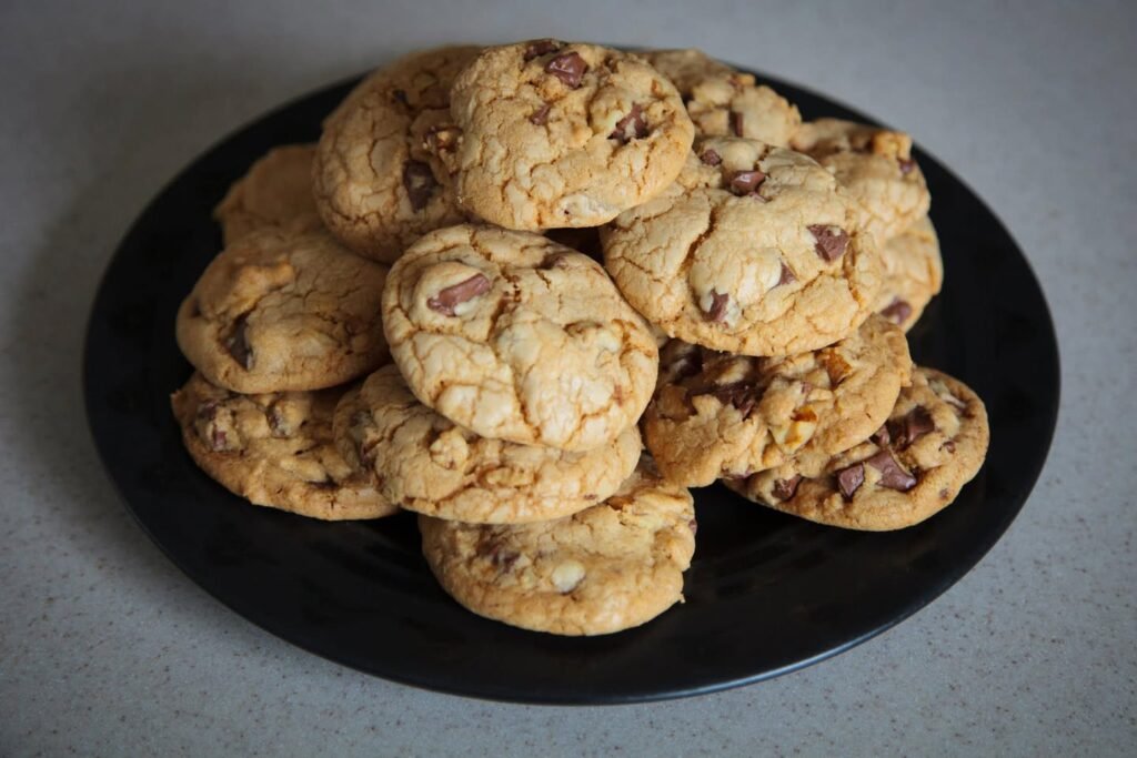 A stack of golden peanut butter chocolate chip cookies piled on a black plate. These easy homemade treats are perfect for sharing with friends or taking on your next trip.