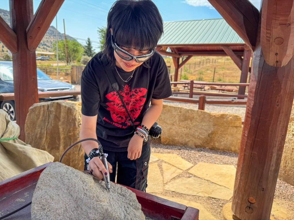John Sandblasting a Rock Under a Wooden Shelter