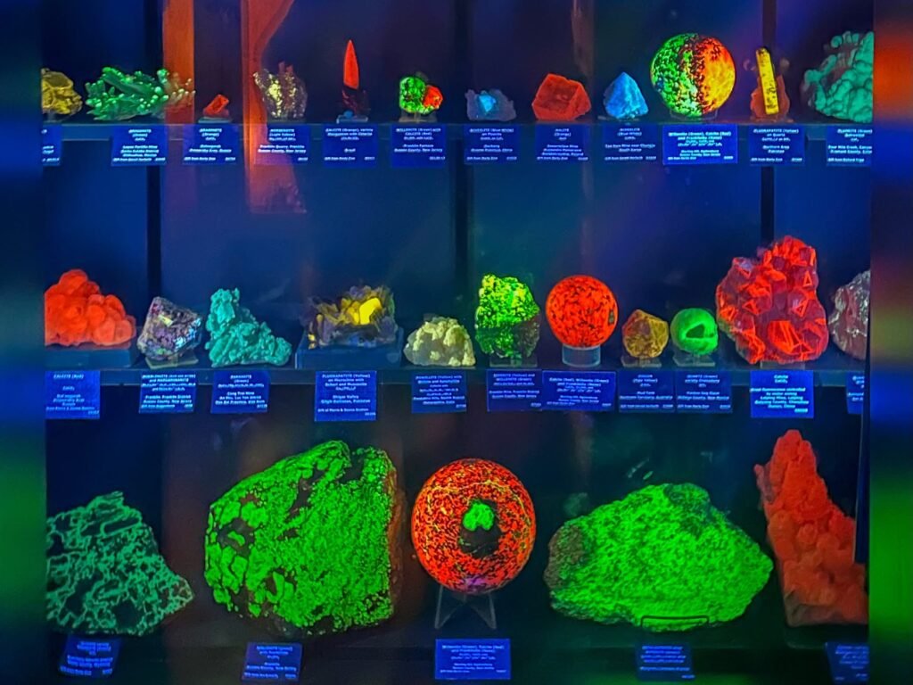 A glowing display of vibrant fluorescent minerals under blacklight, showcasing their vivid colors.