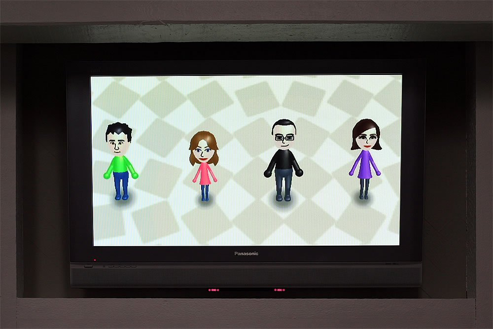 A group of four Mii characters displayed on a Panasonic TV screen, representing John and Kristie's family in a fun, pixelated style.
