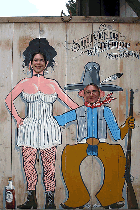 A couple posing with a Winnie the Pooh souvenir photo board from Winthrop Washington. One person is dressed as a cowboy and the other as a western saloon-style woman.
