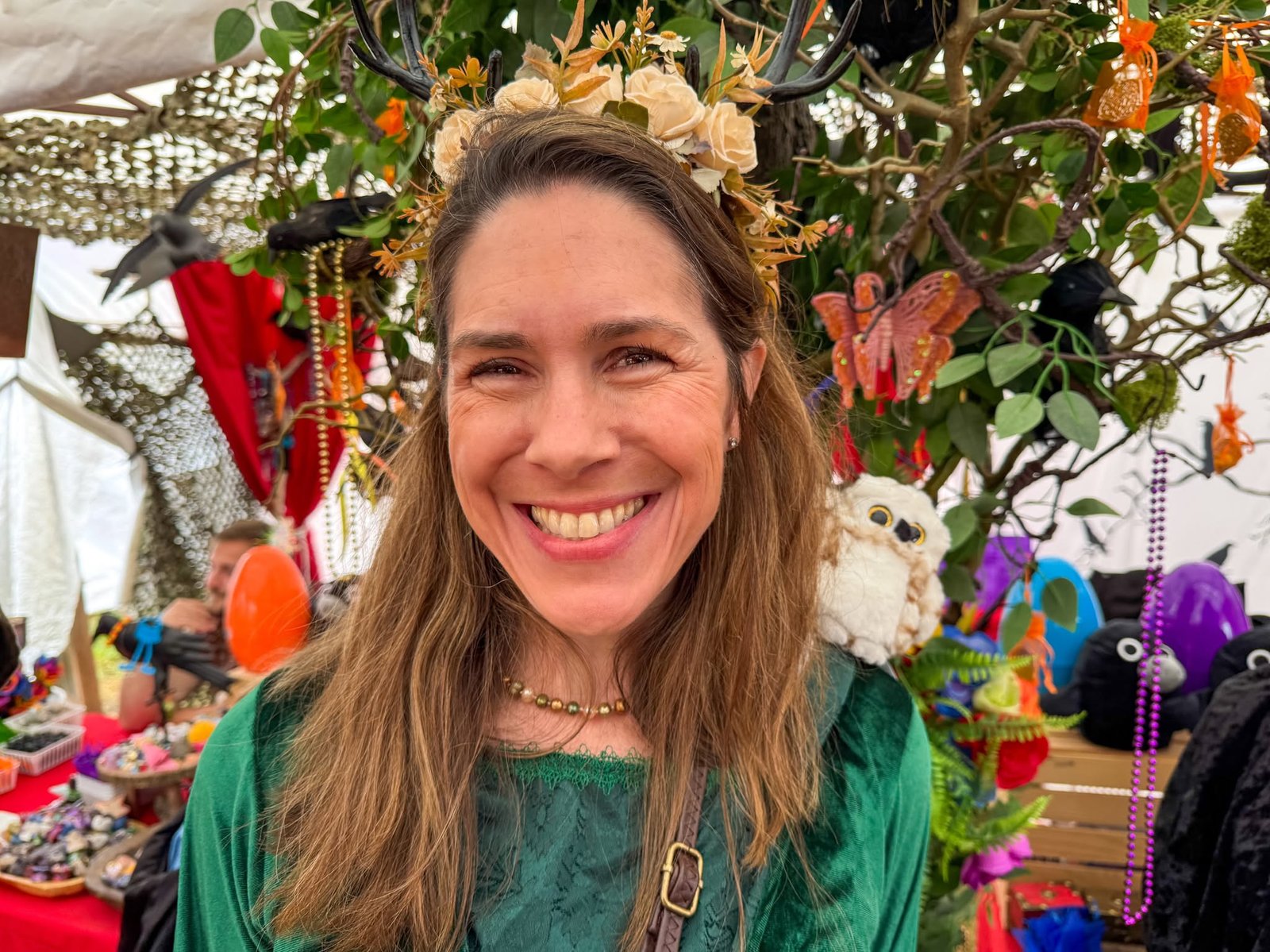 Washington Midsummer Renaissance Faire Woman wearing a flower crown at an outdoor market with festive decorations.