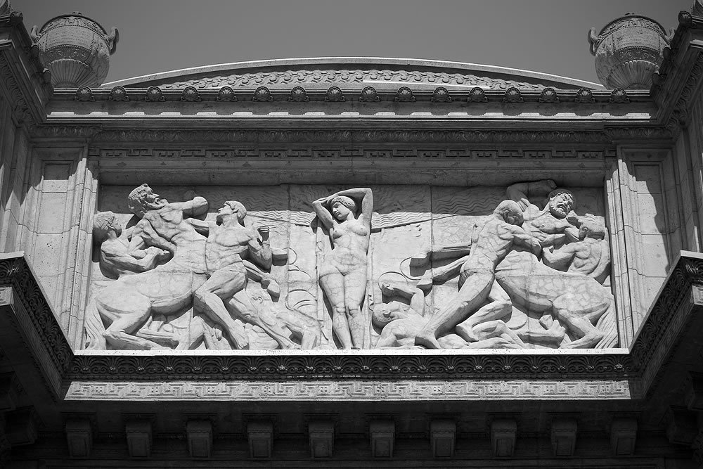 Detailed view of classical marble reliefs and ornate stone carvings on historic building.