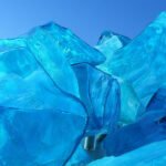 A stunning glass sculpture of vibrant blue ice-like structures against a solid blue backdrop.