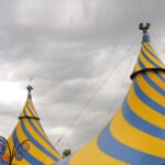 The TSX Yellow and blue striped circus tent top. Metal flag on top of the tent.