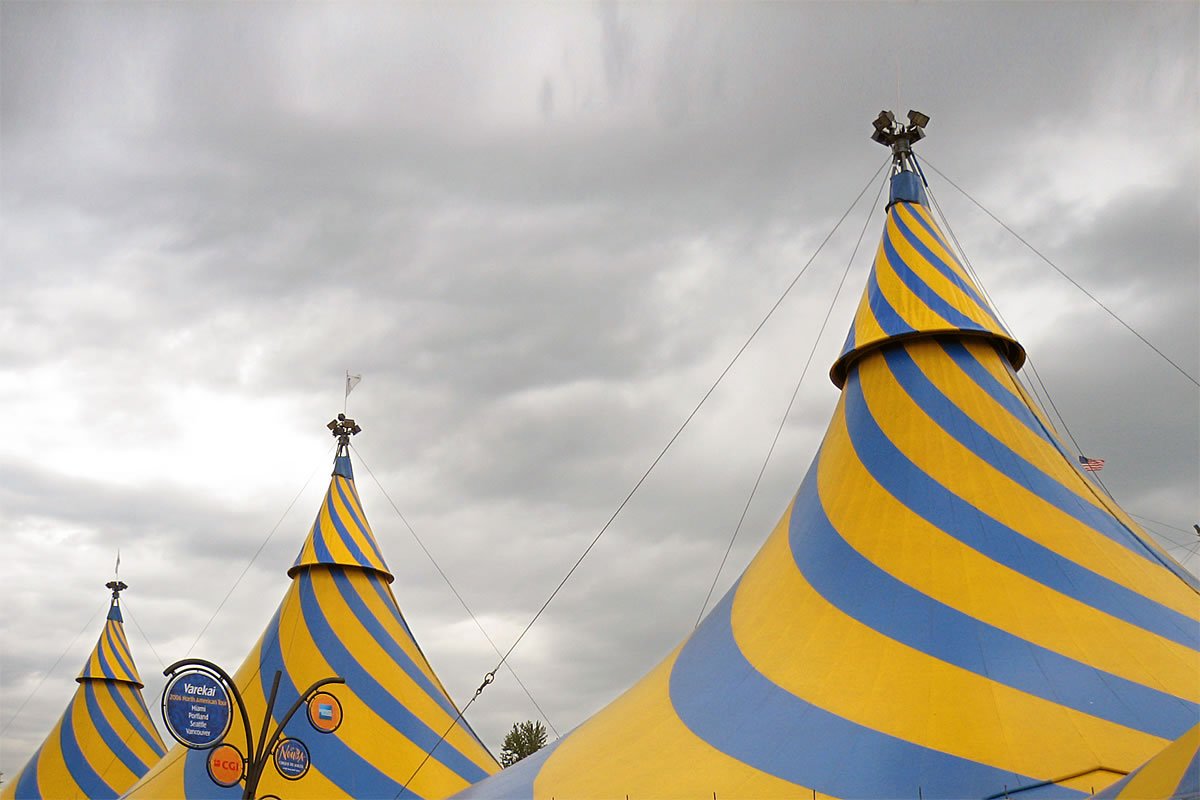 Yellow and blue striped circus tent top. Metal flag on top of the tent.