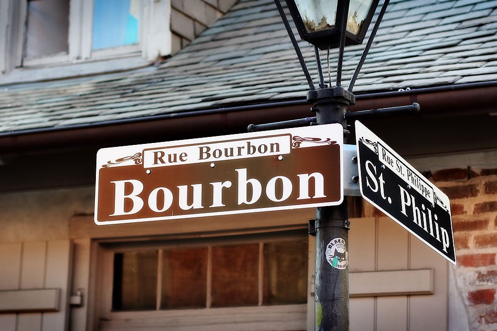 A street sign for Bourbon Street and St. Philip Street in New Orleans, Louisiana, showing a classic urban intersection.