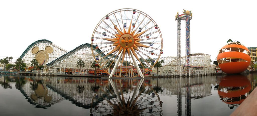California's Great America amusement park with roller coaster, Ferris wheel, and water reflections.