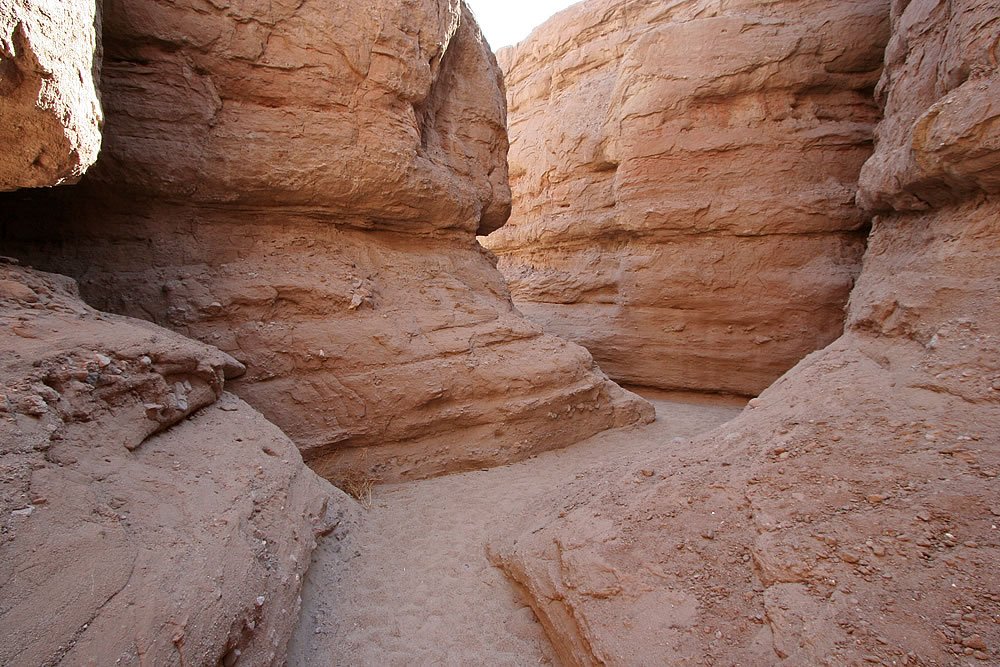 Close-up of layered, reddish-brown canyon walls with dramatic textures and natural erosion patterns.