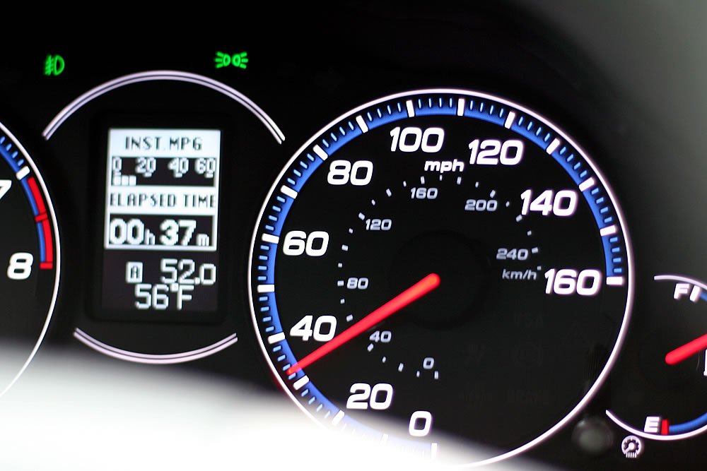 Detailed view of a car speedometer showing mph and km/h, with gauges and digital display.