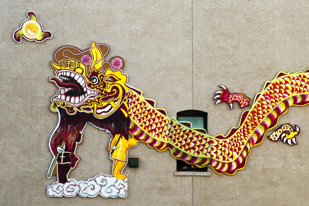 A vibrant Chinese dragon float with scales in red, yellow, and green. The float has an intricate design and traditional elements.