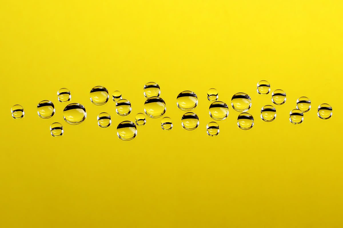 Drops Vibrant circus tents with yellow and blue stripes under a cloudy sky.
