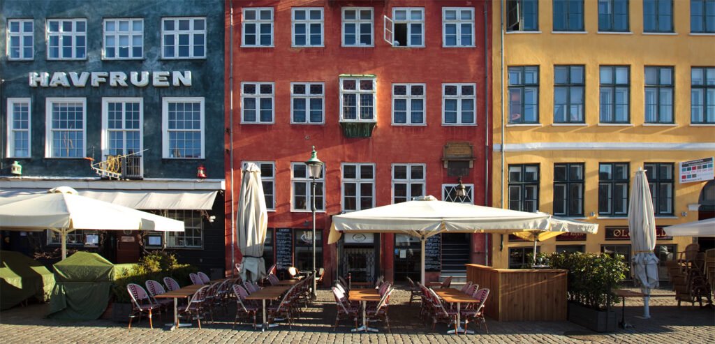 Vibrant buildings with outdoor dining area in the foreground.