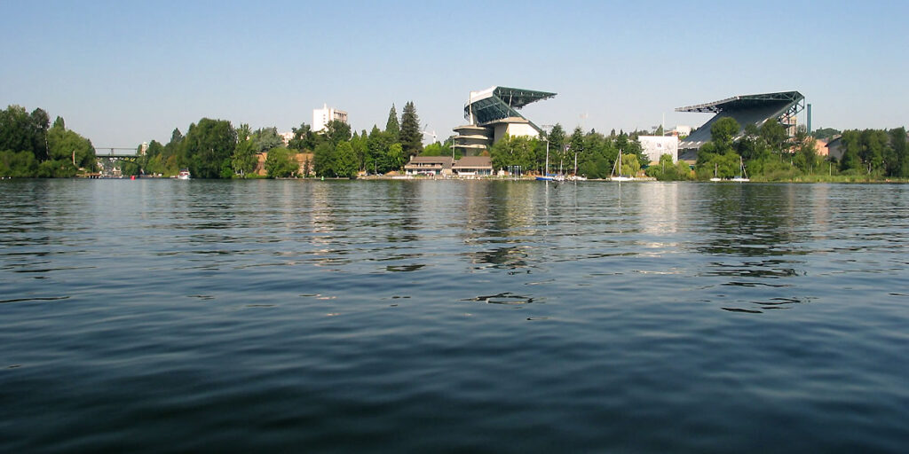 A serene lake view with the Crystal Bridges Museum visible in the background, surrounded by lush greenery.