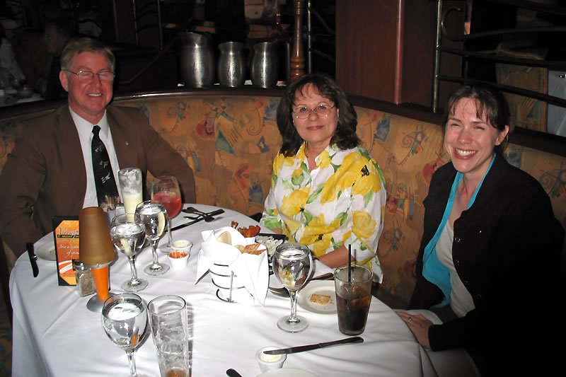 Three people enjoying dinner together at a restaurant, including Kristie and two friends.