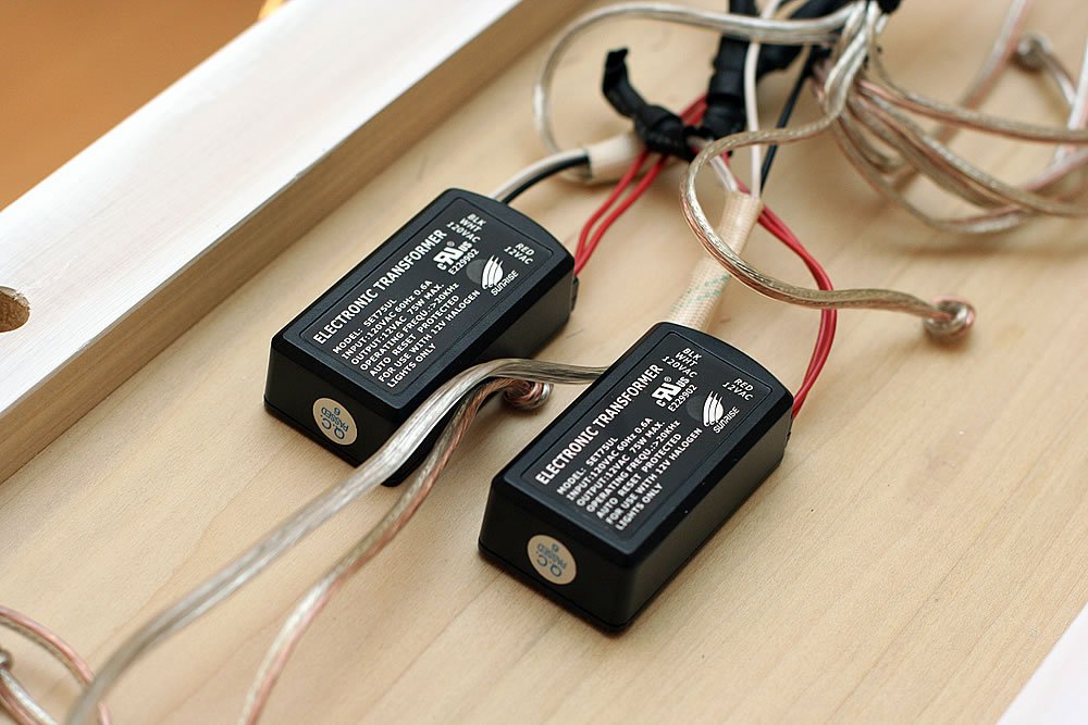Close-up view of battery transformers wired to a wooden DIY project.