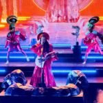 Golden, Colorado Erykah Badu performs live on a brightly lit stage, accompanied by dancers in unique costumes.